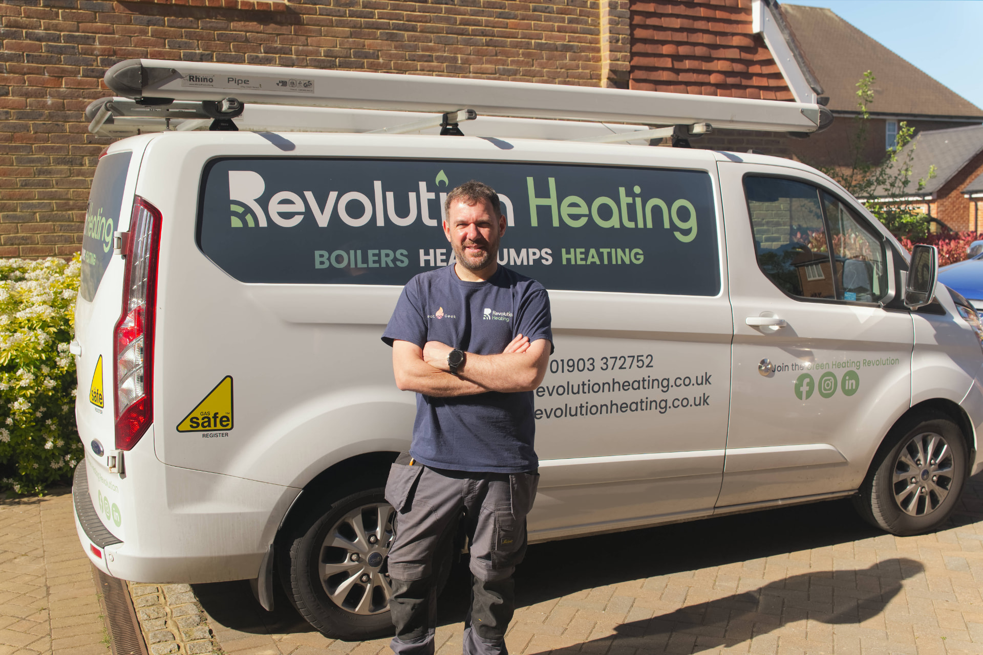 Ben Torbet, heating engineer at Revolution Heating, beside the branded Revolution Heating van