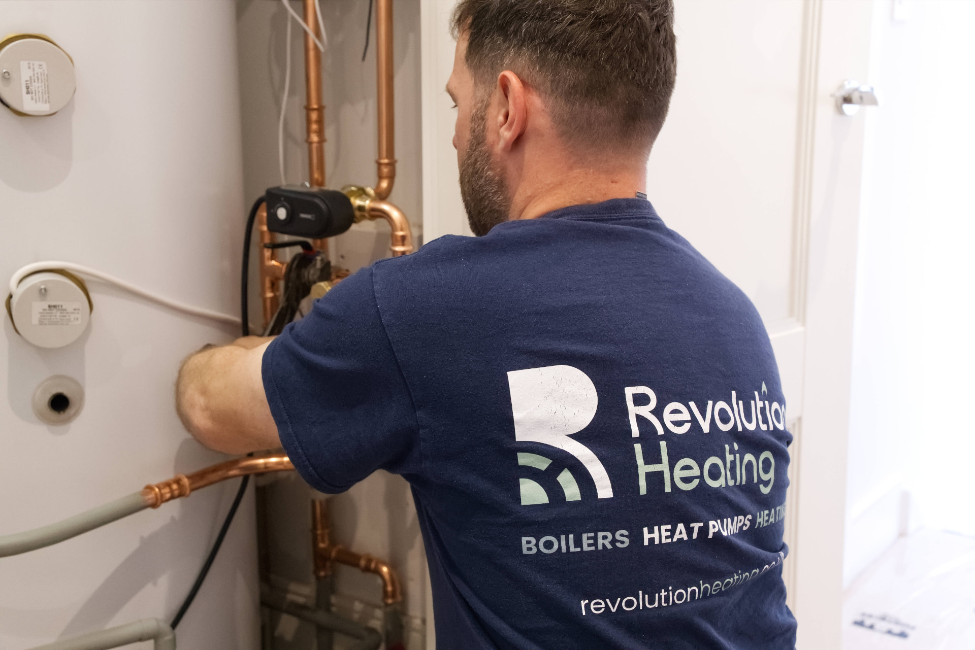 Revolution Heating engineer connecting copper pipework to a hot water cylinder